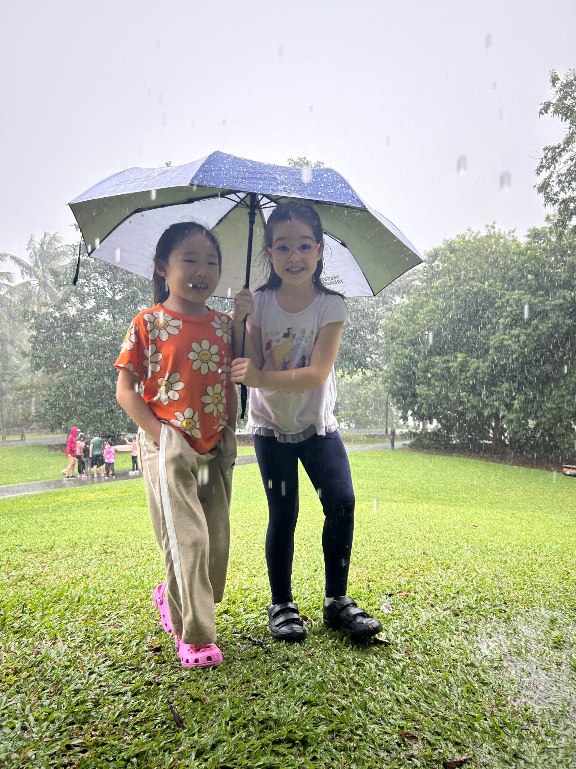 Two girls sharing an umbrella in the rain at Mindful Space Singapore