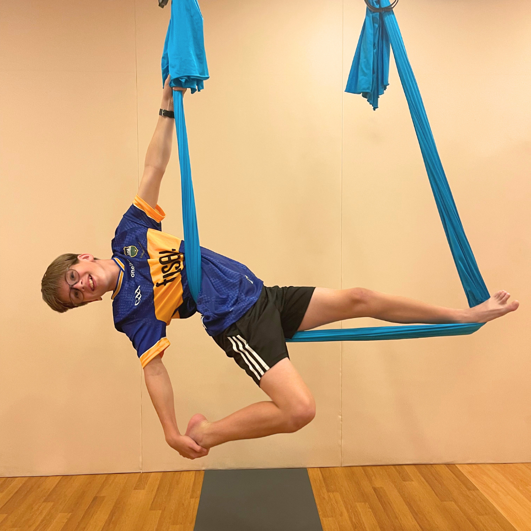 Child building body strength in aerial hammock
