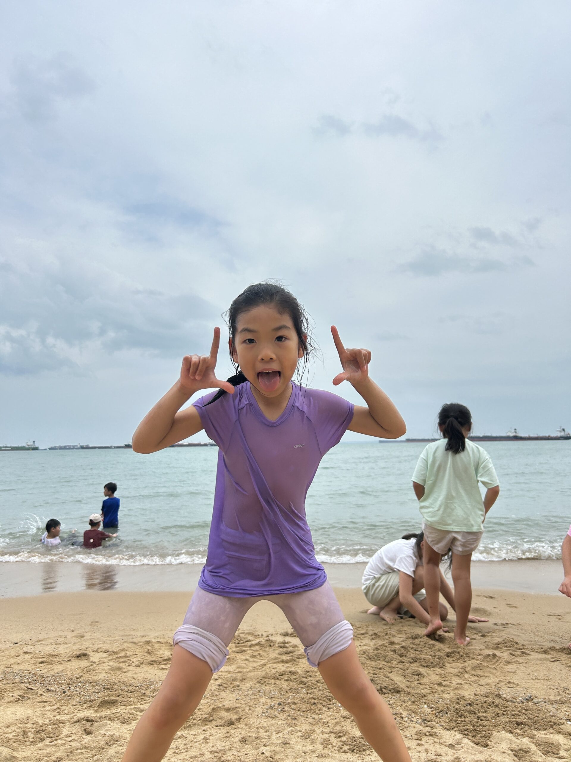 Children exploring nature on the grass at Singapore school holiday camp
