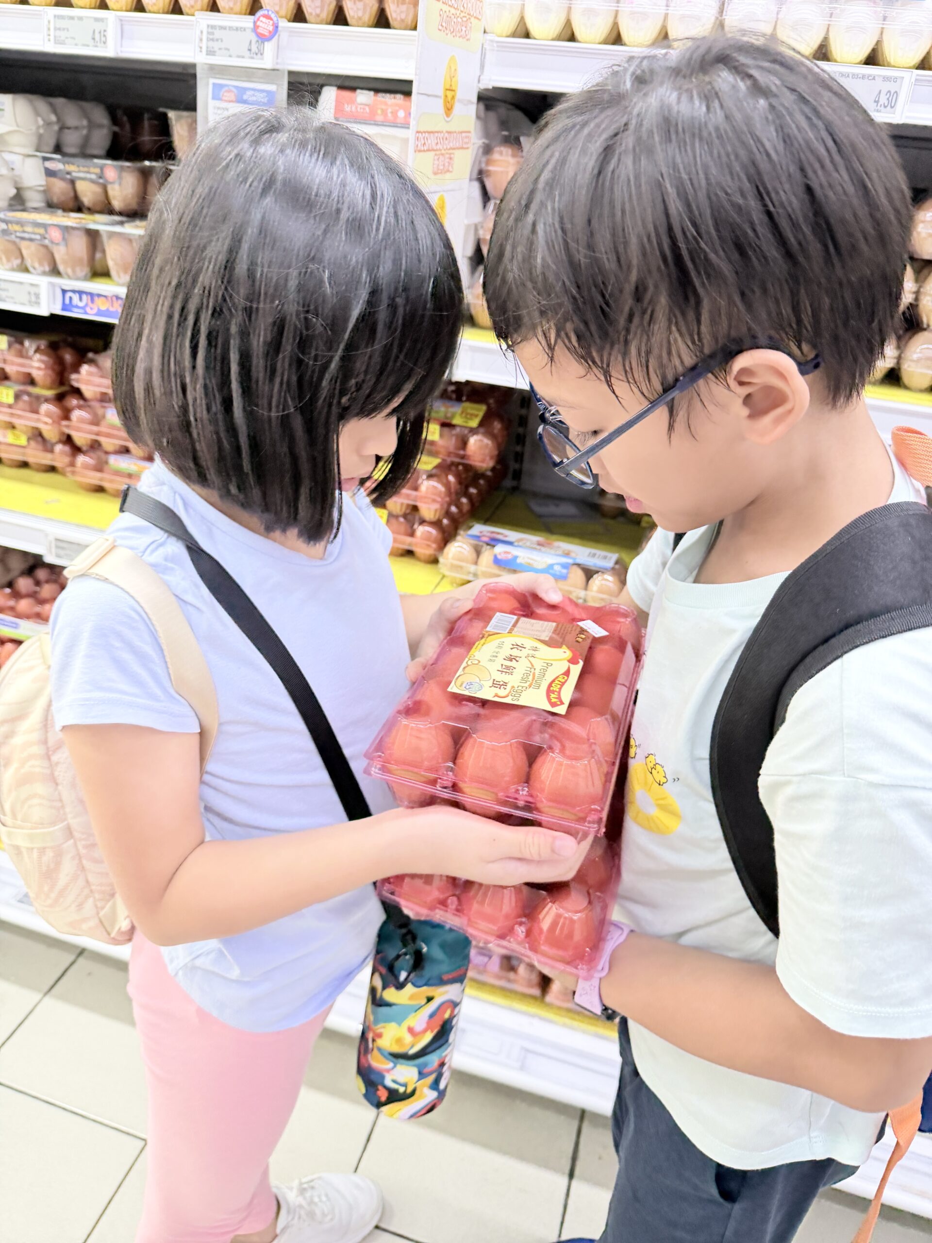 Children grocery shopping and choosing food at Singapore holiday camp